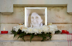 In this file photo taken on October 19, 2017 Flowers and tributes lay at the foot of the Great Siege monument in Valletta, which has been turned into a temporary shrine for Maltese journalist and blogger Daphne Caruana Galizia (picture) who was killed by a car bomb outside her home three days before.