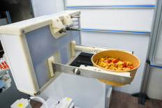 A photo taken on May 25, 2021 shows a robot holding a bowl with a pasta dish after preparation at the Roboeatz eatery in Riga. A pasta order comes in and the robotic arm springs into action at the Roboeatz eatery in Riga. After five minutes of gyrations, a piping hot plate is ready. The Riga cafe is designed in such a way that customers can observe the robotic arm at work. A Roboeatz app allows customers to order and pay for their dish before picking it up at the cafe.
