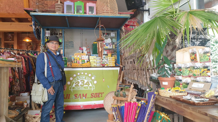 Cure for homesickness: Eka Tanjung, who has lived in the Netherlands for 30 years, stands in front of a kiosk on display at Dierenpark Taman Indonesia in Kallenkote, the Netherlands, complete with the logo of Dji Sam Soe, an iconic brand of Indonesian clove cigarettes. Eka said he visited the park because he was unable to travel home during the pandemic.