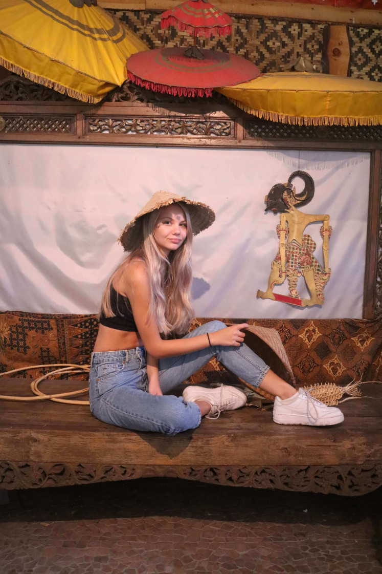 Indonesian holiday at home: Travel and mental health blogger Anouk Ellianne Koster poses with a wayang display at Dierenpark Taman Indonesia in Kallenkote, the Netherlands, as an alternative to her planned trip to Indonesia, which she had to cancel because of COVID-19 restrictions.