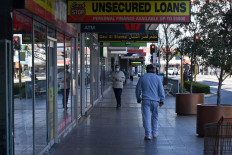 Residents walk through a street in the Fairfield suburb in Sydney on August 2, 2021, during the city's prolonged Covid-19 coronavirus lockdown. 