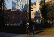 A family walks in Plaza de Mayo, in Buenos Aires, Argentina July 16, 2021. 
