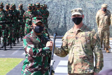 This handout photo taken on August 4, 2021 and released by the Indonesia Army shows Major General Heri Wiranto (left) meeting with US Captain David Moats during a rollcall with Indonesian and US Army soldiers at the Mulawarman headquarters in Balikpapan, East Kalimantan, to kick off the largest-ever joint-training between the armies of the two nations with more than 4,500 soldiers taking part in the Garuda Shield exercise. 