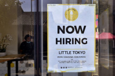 A 'Now Hiring' sign is posted in front of an ice-cream shop in Los Angeles, US, on May 28, 2021. Private hiring by American firms slowed sharply in July to 330,000, with dramatically lower gains in the construction and leisure and hospitality sectors, according to payroll services firm ADP.