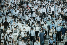 Commuters wear masks at a train station in Tokyo on July 28, 2021, a day after the city reported a record 2,848 new daily cases of Covid-19 coronavirus.
