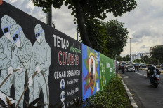 Full compliance: Motorists pass a COVID-19-themed mural in Tebet, South Jakarta, on June 15. 