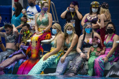 Mermaids and Mermen gather around the main pool for a group photo during MerMagic Con at the Freedom Aquatic Center in Manassas, Virginia on August 7, 2021.
