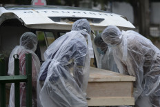 Municipal workers carry the coffin of an unclaimed body of a Covid-19 coronavirus victim to a crematorium in Colombo on December 10, 2020. As the daily virus infections have doubled in a month to more than 2,500 with nearly 100 deaths, the country has begun a mass cremations to clear a backlog of dead bodies.