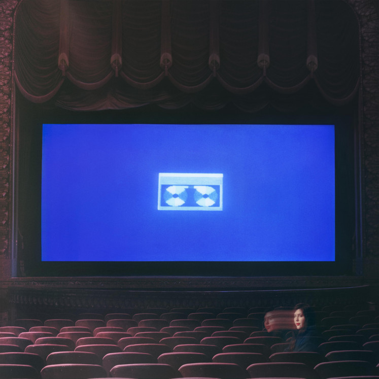 Nostalgic: the cover art of 'Home Video' finds Dacus sitting in her childhood theater as VHS tape's blue screen shines in the dark.