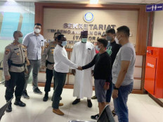 An Indonesian immigration officer and a Nigerian diplomat shake hands at an immigration office in Jakarta in a picture taken this week, with Nigerian ambassador-designate to Indonesia Ari Usman Ogah acting as a witness. (Courtesy of the Jakarta Law and Human Rights Agency)
