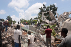 People search through the rubble of what used to be the Manguier Hotel after the earthquake hit on August 14, 2021 in Les Cayes, southwest Haiti. Rescue workers scrambled to find survivors after a powerful 7.2-magnitude earthquake struck Haiti early Saturday, killing at least 304 and toppling buildings in the disaster-plagued Caribbean nation still recovering from a devastating 2010 quake.