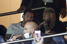 Paris Saint-Germain's Argentinian forward Lionel Messi (left) and Paris Saint-Germain's Brazilian forward Neymar watch the French L1 football match between Paris Saint-Germain and Racing Club Strasbourg at the Parc des Princes stadium in Paris on August 14, 2021.
