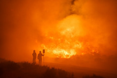 Firefighters operate at the site of a wildfire between Navalacruz and Riofrio near Avila, central Spain, on August 16, 2021.
