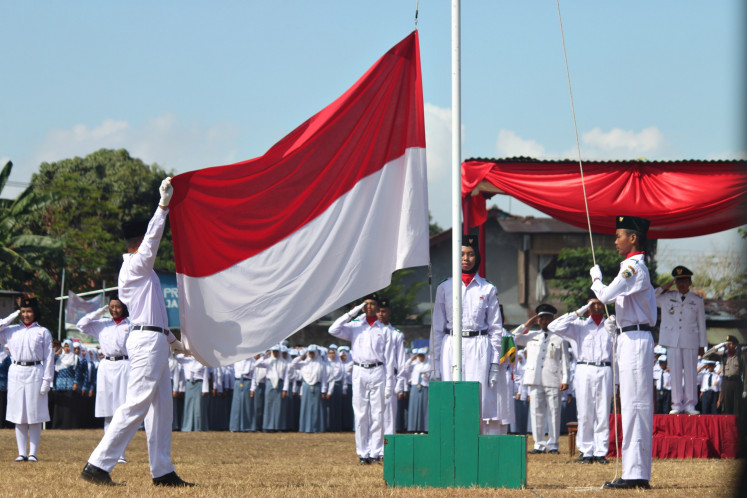 Guts and glory: The national anthem is a fixture at schools and even offices, and is played compulsorily at official and ceremonial events, like this flag-raising ceremony.
