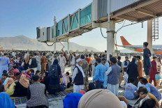 Afghans crowd at the tarmac of the Kabul airport on August 16, 2021, to flee the country as the Taliban were in control of Afghanistan after President Ashraf Ghani fled the country and conceded the insurgents had won the 20-year war. 