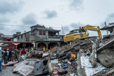 A bulldozer clears the rubble of a building that collapsed in the earthquake in Brefet, a neighborhood of Les Cayes, Haiti, on August 17, 2021. The death toll from a 7.2 magnitude earthquake that struck Haiti has risen to 1,941, the Caribbean nation's civil protection agency said Tuesday, as a tropical storm brought torrential downpours on survivors already coping with catastrophe.