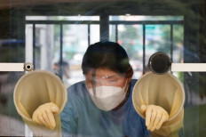 A health worker rests inside a booth as she conducts a coronavirus disease (COVID-19) test at a coronavirus testing site in Seoul, South Korea, July 15, 2021. 
