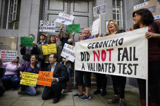 Protesters hold up placards as they gather outside the Department for Environment, Food and Rural Affairs to protest against the decision to euthanize 'Geronimo', an alpaca which has tested positive for bovine tuberculosis, in cental London on August 9, 2021.