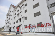 People walk beside the new Kampung Susun Akuarium in Penjaringan, North Jakarta, on Aug. 17, 2021. The Jakarta administration has finished the construction of two blocks of the 'kampung susun' (vertical village), which are expected to welcome residents previously evicted from the area in 2016.
