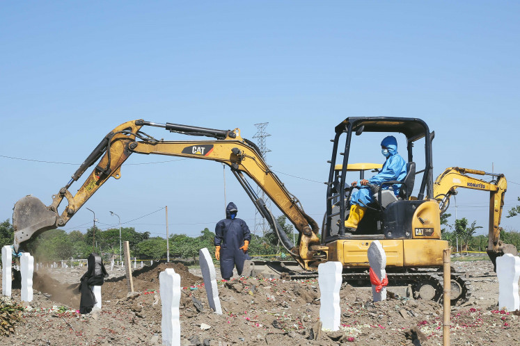 No more room: Gravediggers are forced to use excavators to dig graves and make space for the increasing number of bodies. 
