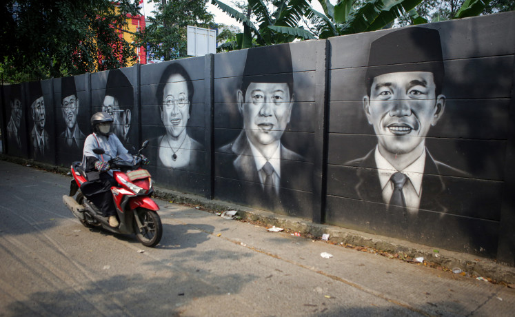 A motorcyclist drives past a mural of Indonesian presidents in Cipondoh, Tangerang, Banten, on Aug. 9. 