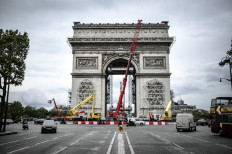 A picture taken on August 4, 2021, in Paris shows the sculptures and the Arc de Triomphe being prepared before the wrapping of the monument, as part of a posthumous monumental installation by late Bulgarian born artist Christo. The monumental work is said to make the Parisian monument disappear under 25,000 square meters of recyclable polypropylene silver and blue fabric and 7000 meters of red rope from September 18 to October 3, 2021 despite Christo's death in may 2020.