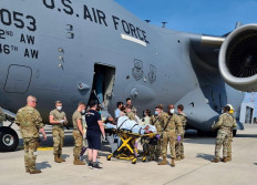 Medical support personnel help an Afghan mother, whose identity has been digitally obscured at source, with her family off a US Air Force C-17 transport aircraft, call sign Reach 828, moments after she delivered a child aboard the aircraft upon landing at Ramstein Air Base, Germany, August 21, 2021. The US Air Force says that the baby girl and mother were transported to a nearby medical facility and are in good condition. 