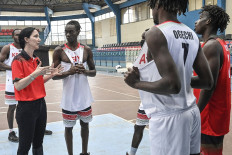 Kenyan Men's National Basketball team head coach Liz Mills (L) talks with the national team after the training session at the Nyayo national stadium gymnasium in Nairobi on August 20, 2021.