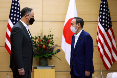 Japan's Prime Minister Yoshihide Suga (right) meets with Douglas Emhoff, husband of US Vice President Kamala Harris, in Tokyo on August 24, 2021. 