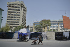 A man pushes a wheelbarrow along a street in downtown Kabul on August 18, 2021 following the Taliban stunning takeover of Afghanistan.