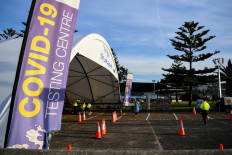 Health workers wait for cars to arrive so they can conduct COVID-19 testing at the St. Vincents Hospital drive-through testing clinic at Bondi in Sydney on July 6, 2021, as the city remains in lockdown for a second week to contain an outbreak of the highly contagious Delta Covid-19 variant. 