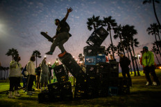 A man falls down of a pyramid of milk crates while he participates of the Milk Crate Challenge, on August 24, 2021 in Venice, California. The Milk Crate Challenge, where participants walk up a pyramid of milk crates has gone viral in recent days on social media. According to US media some doctors are also warning that the injuries from the challenge are putting more stress on hospitals at a time when emergency rooms nationwide are overwhelmed because of the surge in coronavirus.
