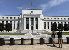 People take pictures of the Federal Reserve building in Washington, DC, on Aug. 6, 2021.