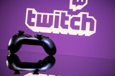 A gamepad is pictured as a screen displays the online Twitch platform in Toulouse, southwestern France, on June 15, 2021.