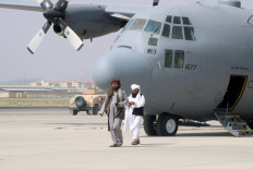 Taliban walk in front of a military airplane a day after the U.S. troops withdrawal from Hamid Karzai International Airport in Kabul, Afghanistan August 31, 2021.