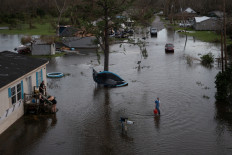 A man walks back to his home after sharing fuel with his neighbors, to use for their generator, in the aftermath of Hurricane Ida in Cut Off, Louisiana, US, August 30, 2021. Picture taken with a drone. 
