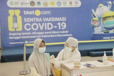 A participant receiving her first dose of Sinovac vaccine at the at the tiket.com Vaccination Center Yogyakarta. 