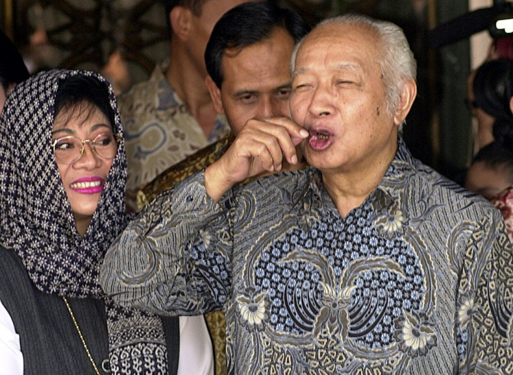 Former Indonesian president Suharto (right) attempts to tell hordes of journalists stalking his residence for the arrival of President Abdurrahman Wahid for a lunch 08 March 2000, that he has difficulty communicating. Suharto is said to be suffering from a slurring speech since he had a minor stroke in June. Accompanied by his eldest daughter Siti 