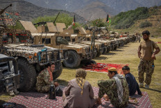 Afghan armed men supporting the Afghan security forces against the Taliban stand with their weapons and Humvee vehicles at Parakh area in Bazarak, Panjshir province on August 19, 2021.
