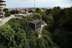 A large metal crate containing 500 bottles of 'xinomavro', a dark-skinned grape variety, is lifted to be sunk by winemakers at the bottom of the Arapitsa river in Naousa, Northern Greece, on September 5, 2021.