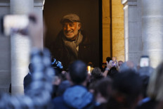 People wait to pay their respects to late French actor Jean-Paul Belmondo as they stand in front of his casket after the national tribute ceremony at the Hotel des Invalides in Paris, on September 9, 2021.