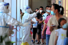 Residents queue to undergo nucleic acid tests for the Covid-19 coronavirus in Xianyou county, Putian city, in China's eastern Fujian province on September 13, 2021. 