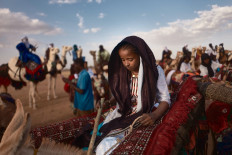 A young woman rides her donkey to attend the annual festival for nomad people called Cure Salee in Ingall, in Niger on September 16, 2021.