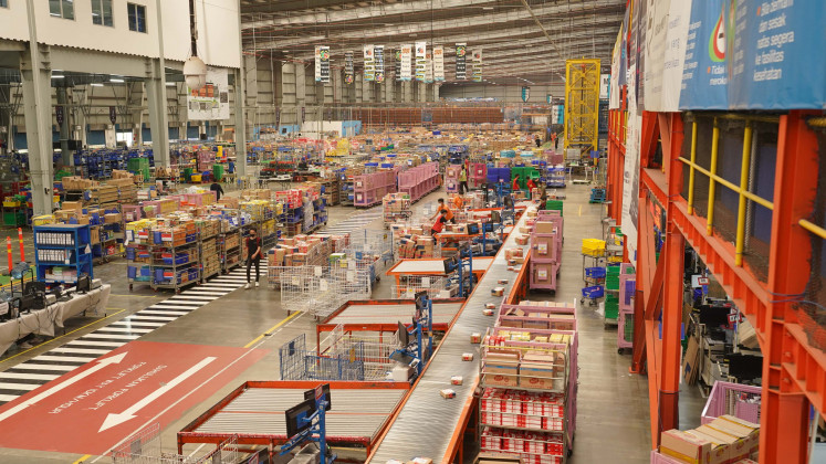 Workers pack and ready orders for shipment at a warehouse of Chinese e-commerce platform Lazada in Indonesia, in this file photo from September 2021