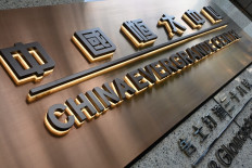 This file photo taken on September 15, 2021 shows signage on the China Evergrande Centre in Hong Kong. Embattled Chinese housing giant Evergrande said on September 22, 2021 it had agreed a deal with domestic bondholders that should allow the conglomerate to avoid default on one of its interest payments.