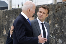 In this file photo US President Joe Biden (L) and France's President Emmanuel Macron speak after the family photo at the start of the G7 summit in Carbis Bay, Cornwall on June 11, 2021. US President Joe Biden and his French counterpart Emmanuel Macron spoke for the first time on September 22, 2021 since a row erupted over the sale of submarines to Australia, vowing to restore confidence damaged by what Paris saw as betrayal. Macron was left furious by Australia's decision last week to ditch a 2016 deal to buy diesel submarines from France in favour of nuclear-powered ones from the United States and Britain, which had been secretly negotiated.