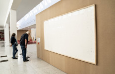 People stand in front of an empty frame hung up at the Kunsten Museum in Aalborg, Denmark, on September 28, 2021.