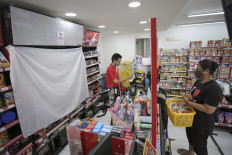 A minimarket in Central Jakarta uses a length of fabric to conceal its cigarette rack in compliance with the new regulation on tobacco advertising, as pictured on Sept. 15, 2021.