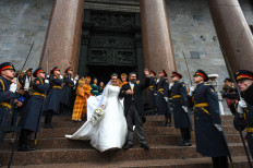 Grand Duke George Mikhailovich Romanov and Victoria Romanovna Bettarini leave the Saint Isaac's Cathedral as Russian honour guards salute them during their wedding ceremony in Saint Petersburg, on October 1, 2021. Russia was to hold its first royal wedding, on October 1, 2021, since the 1917 Bolshevik revolution toppled the Romanov monarchy, with royals from across Europe expected at the lavish ceremony. Grand Duke George Mikhailovich Romanov, 40, and his Italian fiance Rebecca Virginia Bettarini, 39, will say their vows at the Saint Isaac's cathedral in the former imperial capital Saint Petersburg in the presence of dozens of royals.