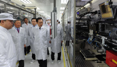 Then-South Korean president Lee Myung-Bak (center) takes a tour around LG Chem's car battery plant before a dedication ceremony in the town of Ochang in Cheongwon county, about 100 km south of Seoul, on April 6, 2011.